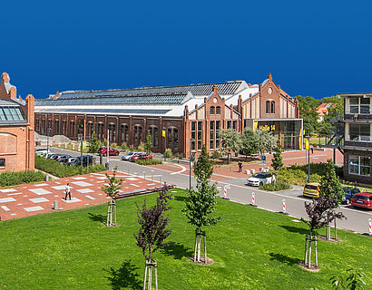 Campus mit Blick auf Halle 14 vor blauem Hintergrund
