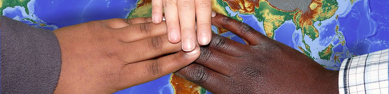 Verschiedenfrabige Hände auf einer Weltkarte