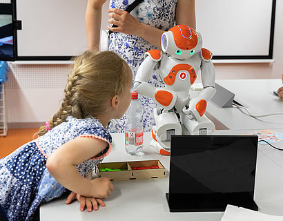 Kleiner androider Roboter und Mädchen