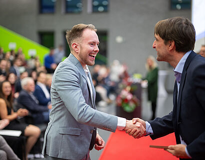 Prof. Rainer Stollhoff gratuliert einem Absolventen