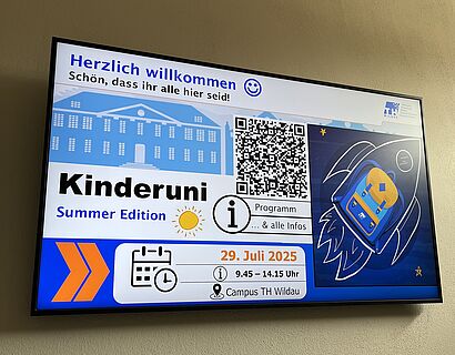 Kinderuni Summer Edition 2025 - Screen im Gebäude der TH Wildau zeigt Folie mit Kinderuniinfos