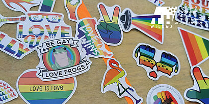 Aufkleber in Herzform und mit Regenbogenmuster liegen auf einem Tisch