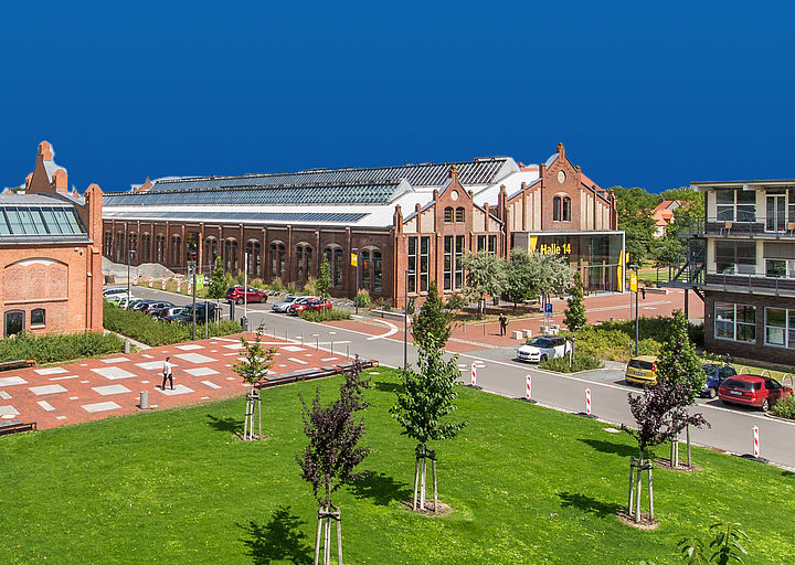 Campus mit Blick auf Halle 14 vor blauem Hintergrund