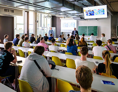 Studieninteressierte von hinten fotografiert in einem Seminarraum beim HIT 2026
