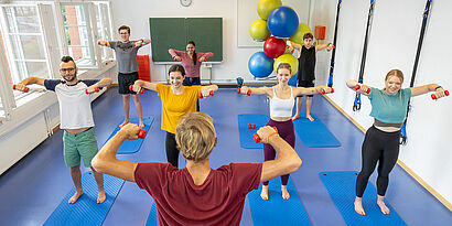Studierende beim Hanteltraining im Sportraum der TH Wildau 