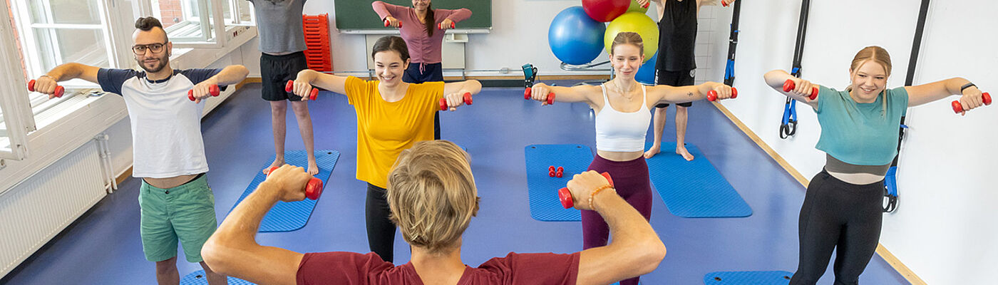 Studierende beim Hanteltraining im Sportraum der TH Wildau 