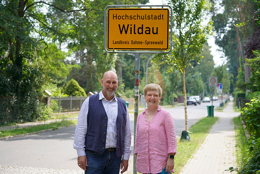 Hochschulstadt Wildau Wildaus Bürgermeister Frank Nerlich und TH-Wildau-Präsidentin Prof. Ulrike Tippe vor einem Ortseingangsschild der Hochschulstadt Wildau