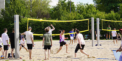 Beachvollerballer/-innen auf dem Spielfeld des Campus 