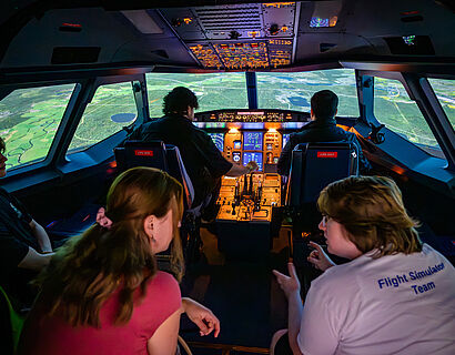 Studieninteressierte sitzen von hinten fotografiert im Flugsimulator A320 beim HIT 2026 der TH Wildau
