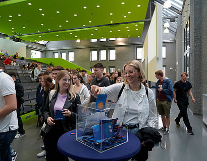 Studentinnen beim Einwerfen von beschriebenen TH-Wildau-Postkarten in eine Plexiglas-Box