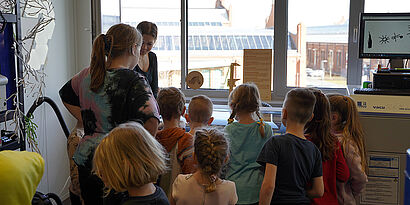 Kinder mit dem Rücken zur Kamera stehend bei einem Workshop im ViNN:Lab der TH Wildau.