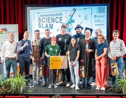 Gruppe auf einer Bühne vor einer Kinoleinwand