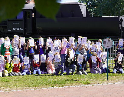 Gruppenfoto Kinderuni Summer Edition 2025 vor der Lokomotive auf dem Campus der TH Wildau