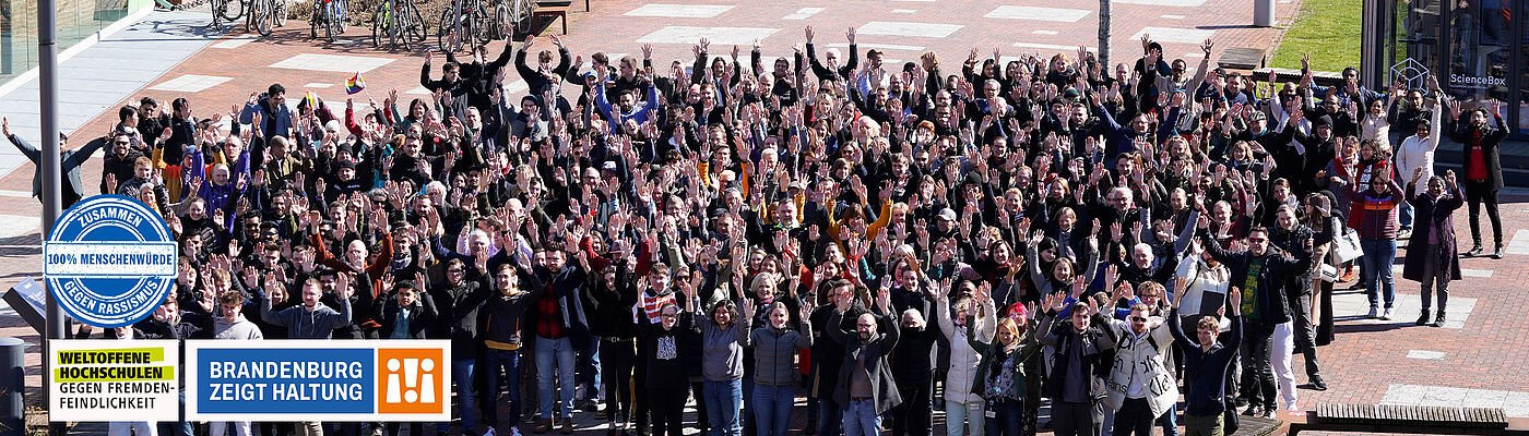 Gruppenfoto auf dem Campus der TH Wildau mit Logo Brandenburg zeigt Haltung und Logo Zusammen gegen Rassismus