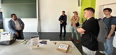 Herr Achtermann im Gespraech mit Studenten