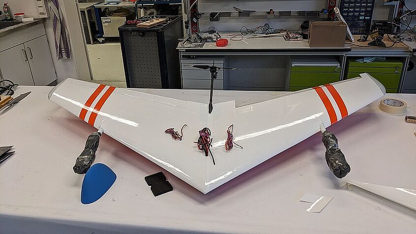 6G-NeXt-Nurflügeldrohne -Bau: Die Drohne ist eine Eigenentwicklung und Teil des Use-Case "Smart Drones", in dem ein Antikollisionssystem für Drohnen entwickelt wird, sowie Ausstellungsstück der TH Wildau auf der AERO 2024. Bild: TH Wildau Auf dem Bild ist eine 6G-NeXt-Nurflügeldrohne im Bauzustand zu sehen.
