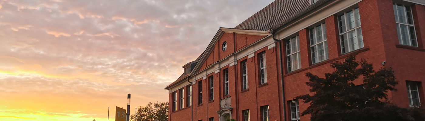 Sonne geht neben Gebäude auf