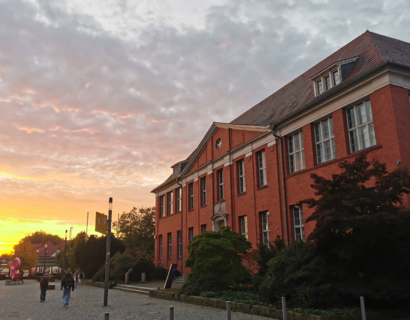 Sonne geht neben Gebäude auf