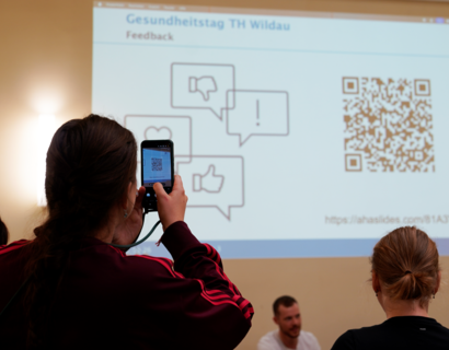 Person scannt QR Code mit dem Handy