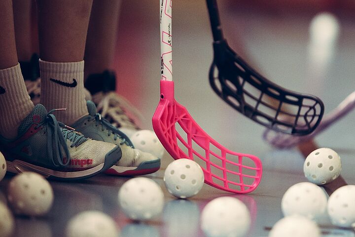 Unihockey Hockeybälle auf dem Boden mit Schlägern daneben