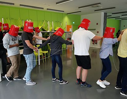 Teambuilding Gruppe mit roten Helmen