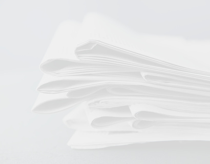 Zeitungsstapel auf grauem Untergrund 