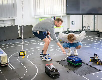 Professor der TH Wildau erklärt einem Studierenden die Minitrucks im neuen Future Mobility Lab der Hochschule. 