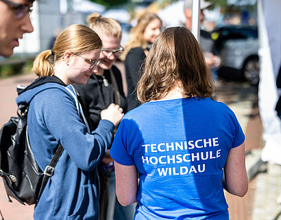 Studentin erklärt am Informationsstand