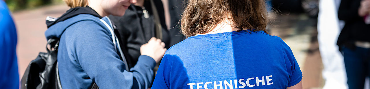 Studentin erklärt am Informationsstand