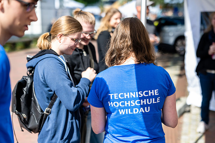 Studentin erklärt am Informationsstand