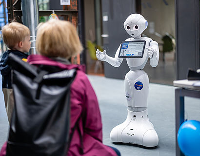 Roboter erklärt zwei Personen etwas