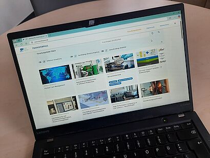 Zu sehen ist ein Laptop der die Website von dem Transferpass aufzeigt