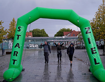 Wander/-innen beim Zieleinlauf im Regen