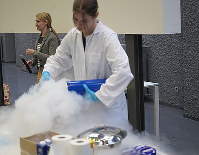 Kinderuni Winter Edition 2024 - Eine Mitarbeiterin bereitet ein Experiment vor