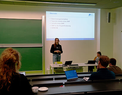 In dem Foto ist eine Person zu sehen, die einen Vortrag hält.