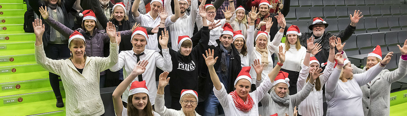 Beschäftigte der TH Wildau mit Weihnachtsmützen im Audimax