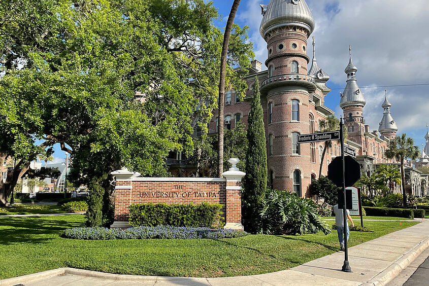 Hauptgebäude der University of Tampa mit Teil der Wiese und Straße davor