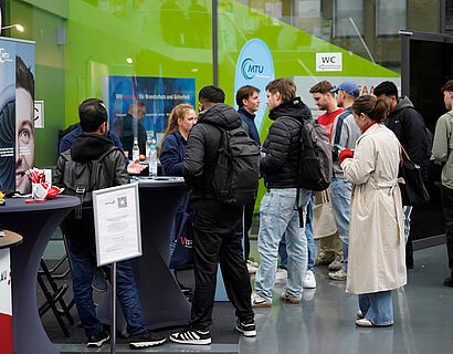 Besucher*innen am Stand bei der THCONNECT 2025 bei einem Gespräch