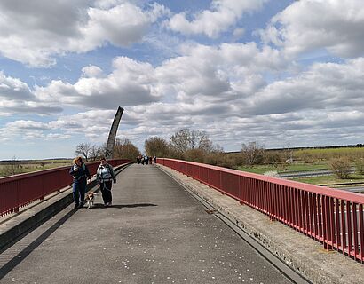 Wanderer gehen über eine Autobahnbrücke