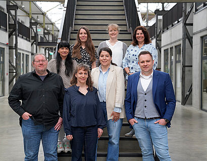 Gruppenfoto von mehreren Personen auf einer Treppe