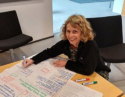 Lehrende arbeitet auf Flipchart