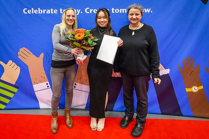 Auf dem Bild sind eine Studentin und zwei Lehrende des Studiengangs Telematik bei der Preisverleihung zu sehen.