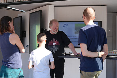 Personen stehen in der ScienceBox auf dem Campus der TH Wildau und unterhalten sich