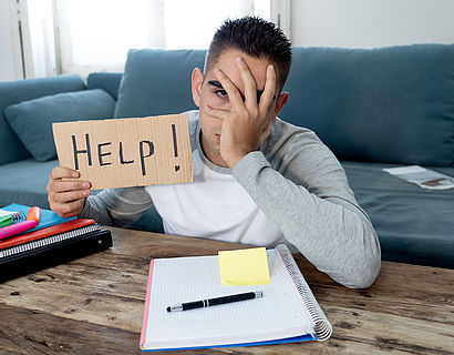 Studierender hält Schild mit Aufschrift Help hoch