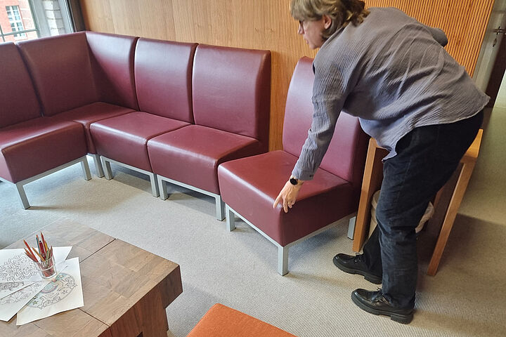 Eine Frau verrückt einen Polsterstuhl