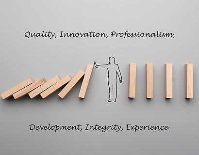Dominosteine, die umfallen mit Begriffen Quality, Innovation, Professionalism, Development, Integrity, Experience