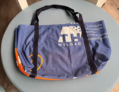 Aus HIT Bannern genähte blaue Tasche der Stiftung Lobetal mit großem weißen TH-Wildau-Logo