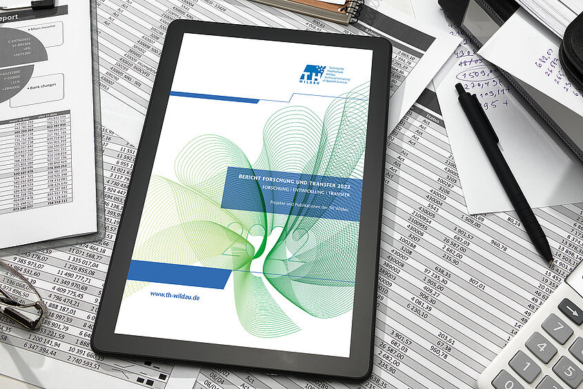Bericht Forschung und Transfer Tablet mit Bild des Berichts Forschung und Transfer 2022 der TH Wildau auf dem Screen