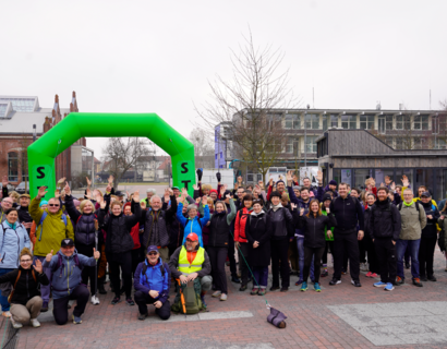 Eine Gruppe Menschen steht unter einem Bogen mit der Aufschrift Start