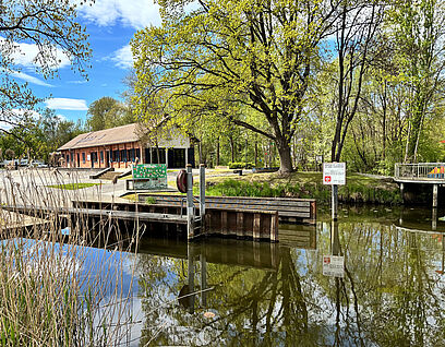 Wasser mit Steg und Haus im Hintergrund